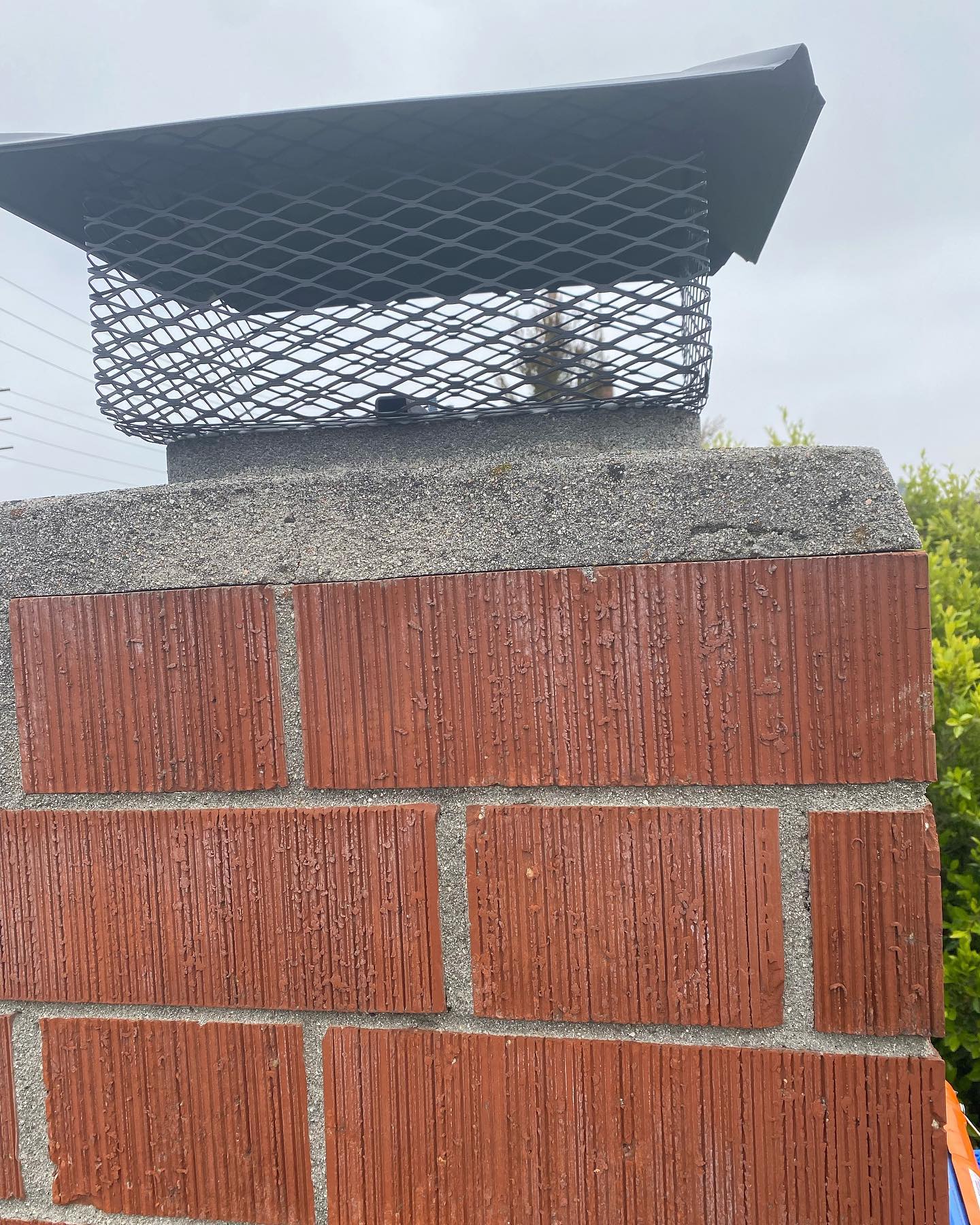 Close-up of a finished chimney cap fitted on a brick chimney